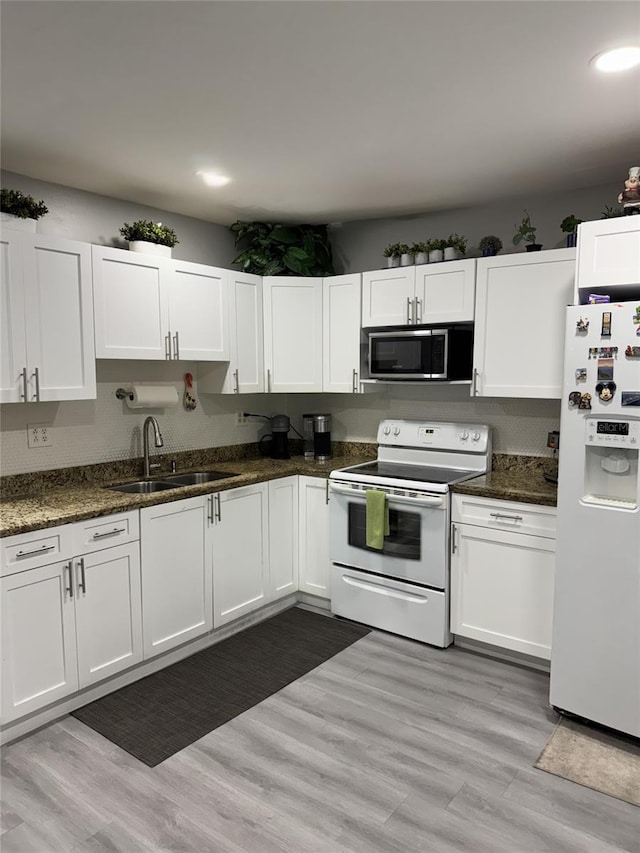 3565 NW 81st Ter, Miami, FL 33147 - kitchen with white appliances, dark stone countertops, a sink, and white cabinets