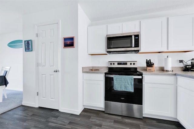 kitchen with white cabinets, stainless steel appliances, and dark hardwood / wood-style floors