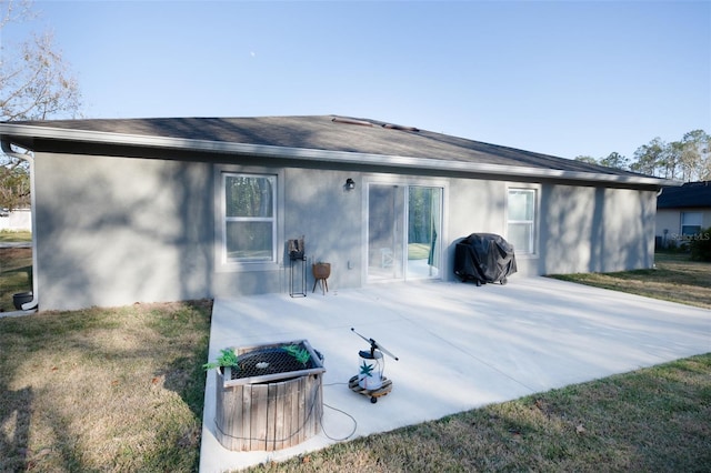 back of property featuring a lawn and a patio