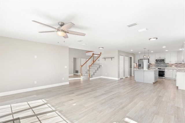 unfurnished living room with light hardwood / wood-style flooring and ceiling fan