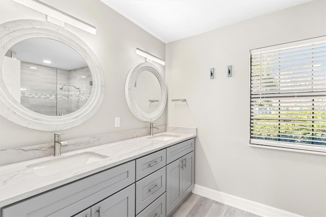 bathroom with tiled shower and vanity