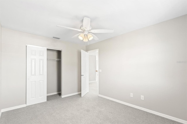 unfurnished bedroom with ceiling fan, a closet, and light colored carpet