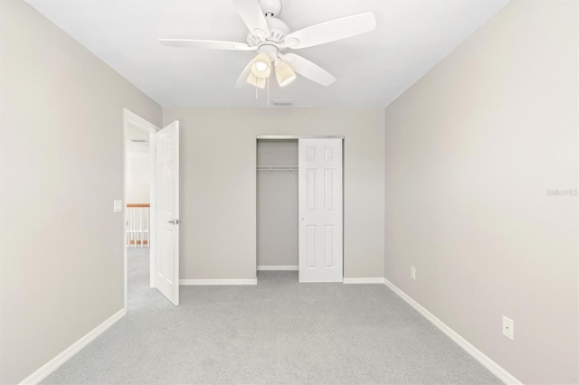 unfurnished bedroom featuring ceiling fan, a closet, and light carpet