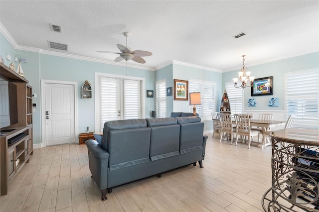 living room featuring a textured ceiling, ceiling fan with notable chandelier, and crown molding