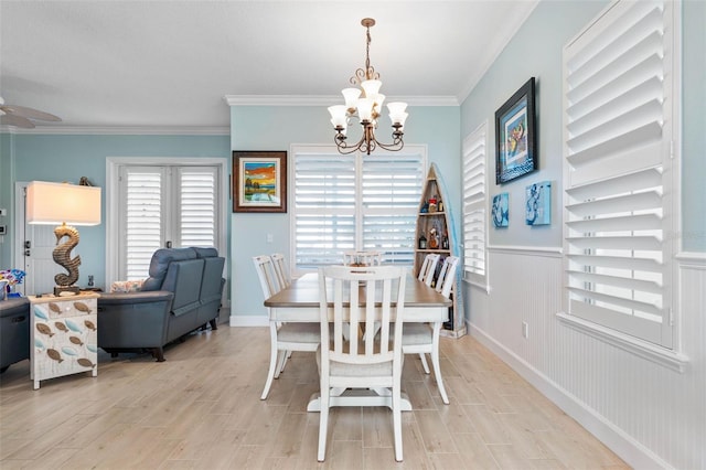 dining room with ceiling fan with notable chandelier, light hardwood / wood-style floors, and ornamental molding