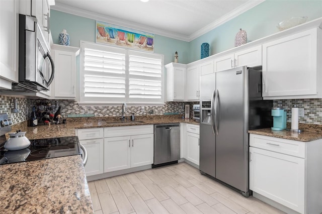 kitchen featuring white cabinetry, sink, stone counters, stainless steel appliances, and decorative backsplash