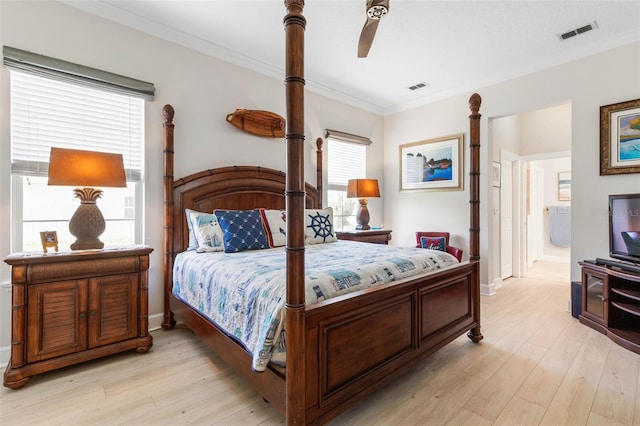 bedroom with ceiling fan, light wood-type flooring, ornamental molding, and connected bathroom