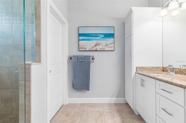 bathroom with tile patterned floors, vanity, and tiled shower