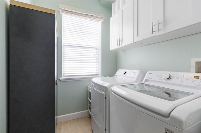 laundry room with cabinets, light wood-type flooring, and independent washer and dryer