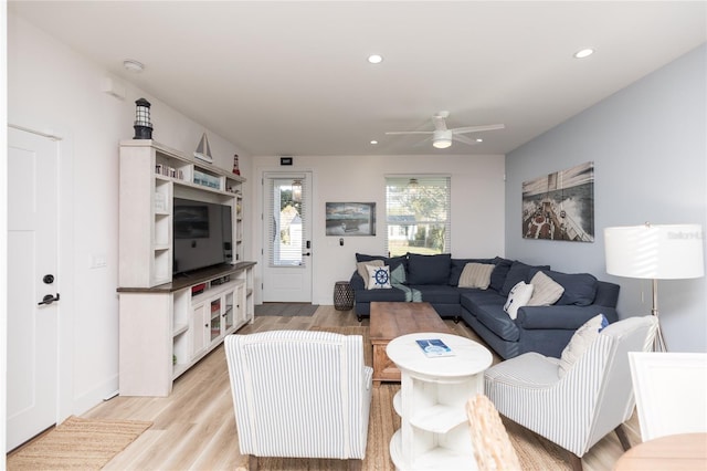 living room featuring light hardwood / wood-style flooring and ceiling fan