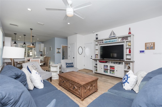 living room with ceiling fan and light hardwood / wood-style flooring