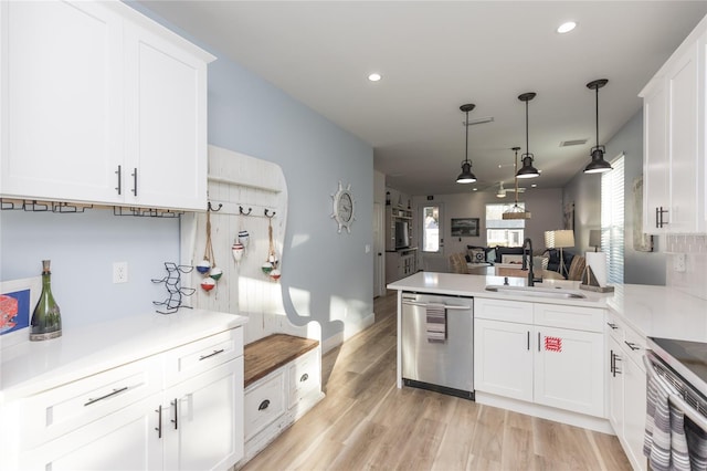 kitchen with white cabinetry, sink, stainless steel dishwasher, kitchen peninsula, and decorative light fixtures