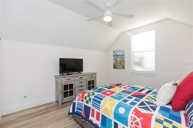 bedroom featuring ceiling fan, light wood-type flooring, and vaulted ceiling