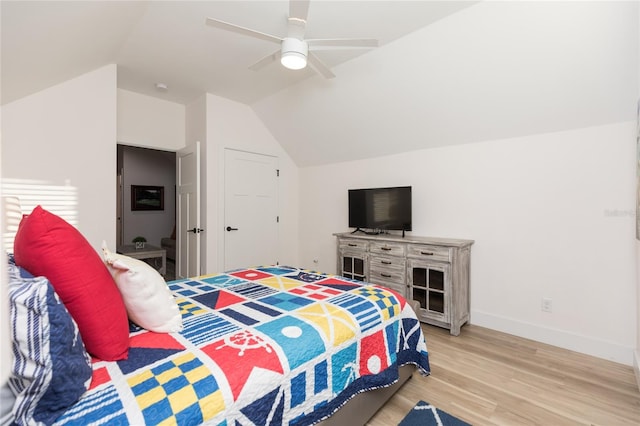 bedroom featuring light hardwood / wood-style floors, vaulted ceiling, and ceiling fan