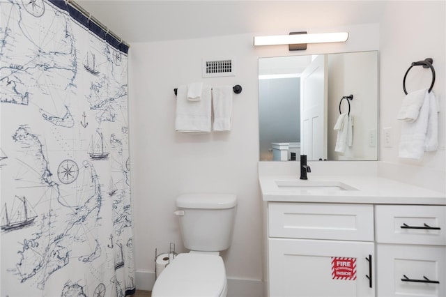 bathroom featuring curtained shower, vanity, and toilet