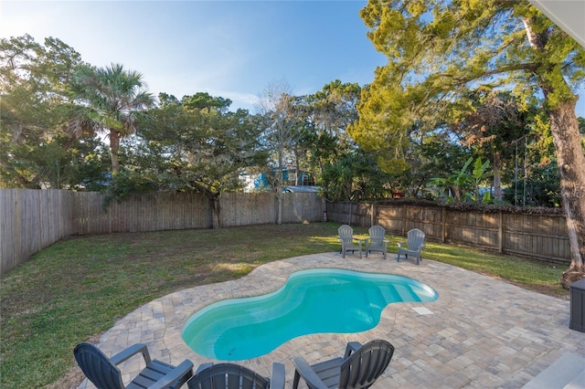 view of swimming pool featuring a yard and a patio area