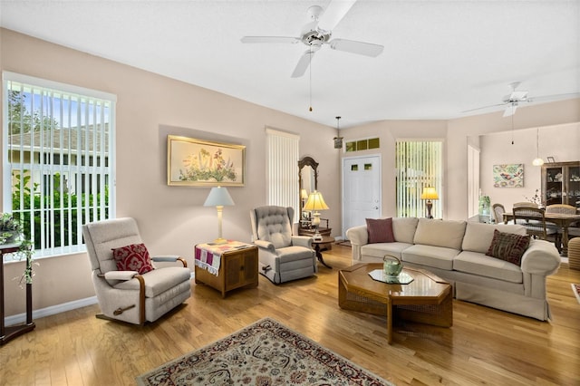 living room with ceiling fan and light hardwood / wood-style flooring