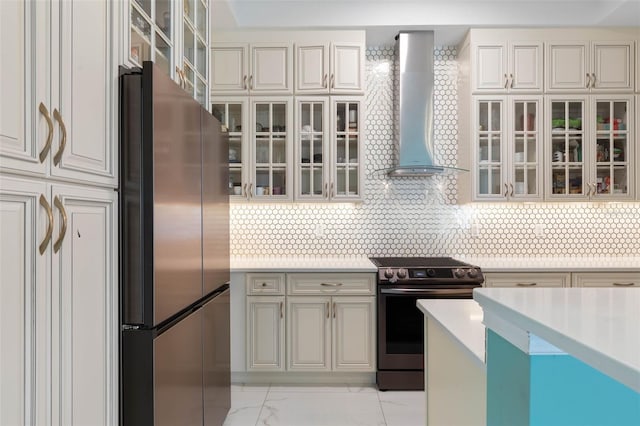 kitchen with stainless steel refrigerator, decorative backsplash, electric stove, and wall chimney exhaust hood