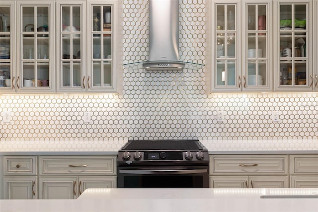 kitchen featuring stainless steel stove and wall chimney range hood