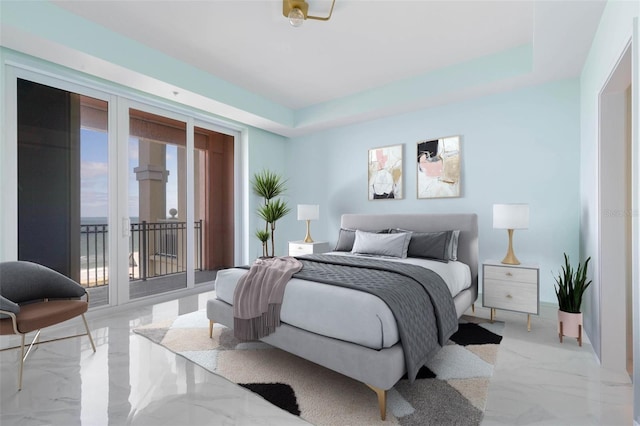 bedroom with access to exterior and a tray ceiling