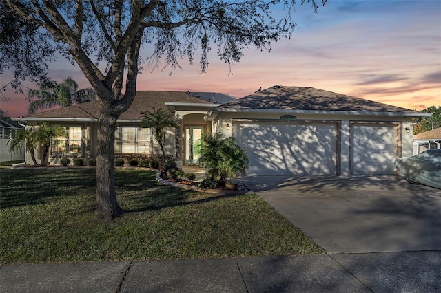 single story home with a yard and a garage