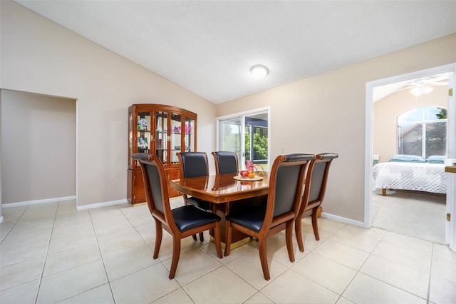 dining space with ceiling fan, light tile patterned flooring, and lofted ceiling