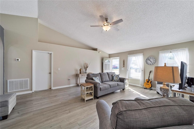 living room with ceiling fan, a healthy amount of sunlight, lofted ceiling, and light wood-type flooring