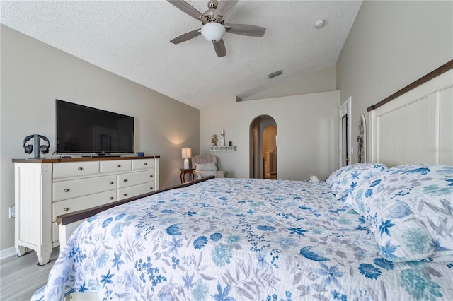 bedroom featuring a textured ceiling, ceiling fan, and lofted ceiling