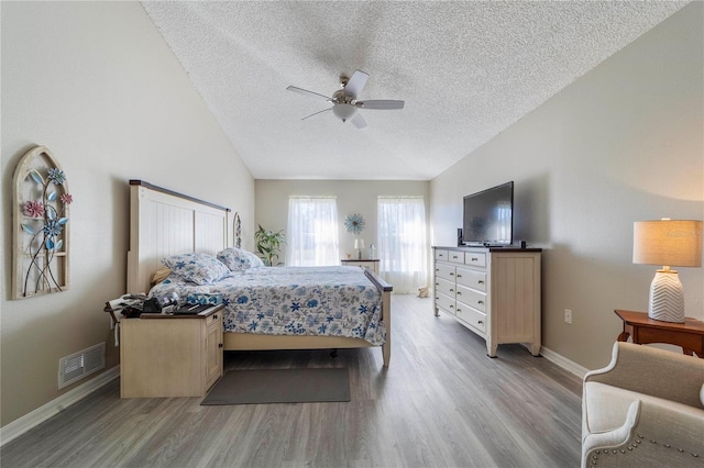 bedroom with ceiling fan, a textured ceiling, and light hardwood / wood-style flooring