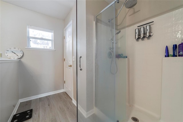 bathroom featuring hardwood / wood-style floors and a shower with shower door