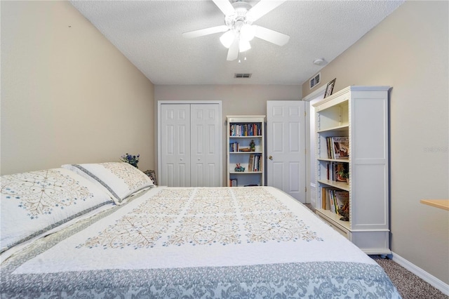 carpeted bedroom featuring ceiling fan, a closet, and a textured ceiling