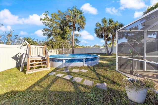 view of swimming pool featuring a yard, a lanai, and a wooden deck