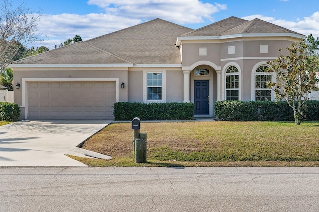 view of front of home with a garage and a front lawn