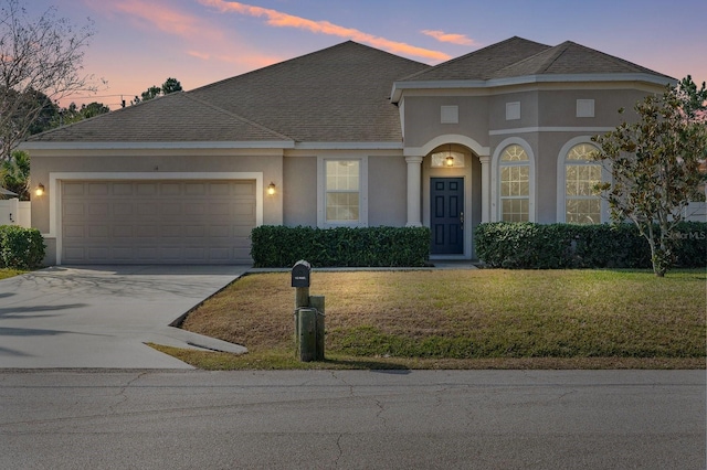 view of front facade featuring a garage and a lawn