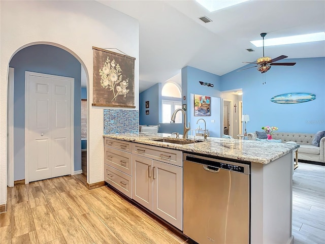 kitchen with light stone counters, tasteful backsplash, stainless steel dishwasher, and sink