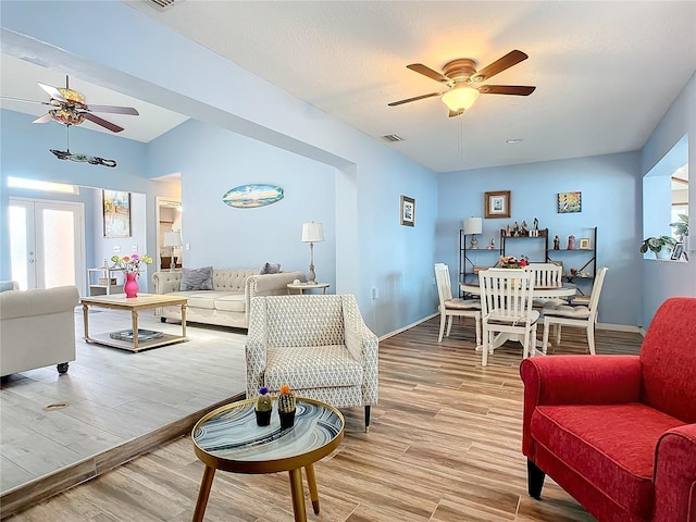 living room featuring wood-type flooring and ceiling fan