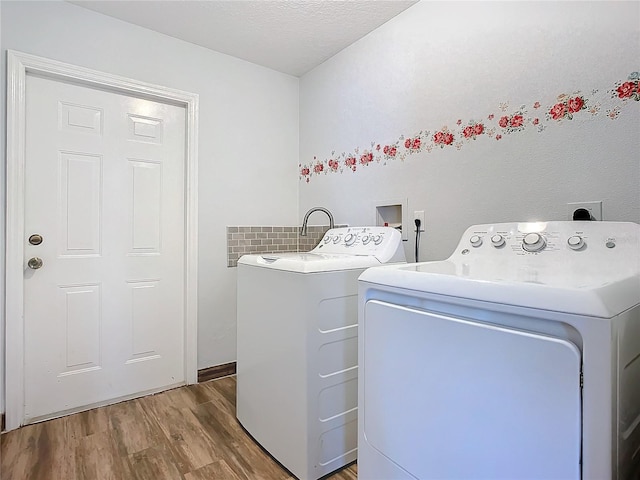 washroom featuring hardwood / wood-style floors, a textured ceiling, and washing machine and clothes dryer