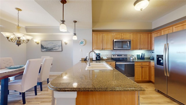 kitchen with stainless steel appliances, sink, light hardwood / wood-style flooring, a chandelier, and hanging light fixtures