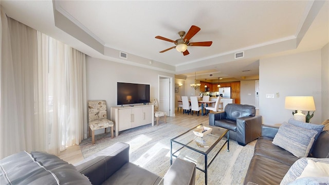 living room with light hardwood / wood-style flooring, a raised ceiling, ceiling fan, and crown molding