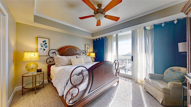 carpeted bedroom featuring access to outside, crown molding, ceiling fan, a textured ceiling, and a tray ceiling