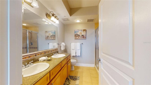 bathroom with tile patterned floors, a shower with door, vanity, and toilet