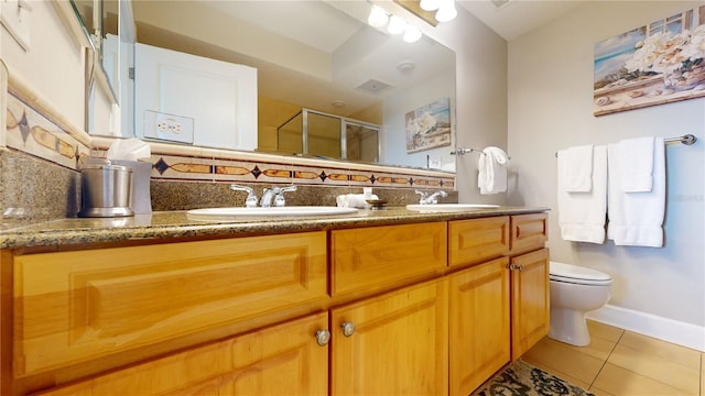 bathroom with vanity, tile patterned flooring, decorative backsplash, toilet, and a shower with shower door