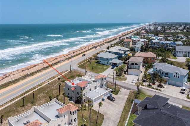 birds eye view of property featuring a water view and a beach view