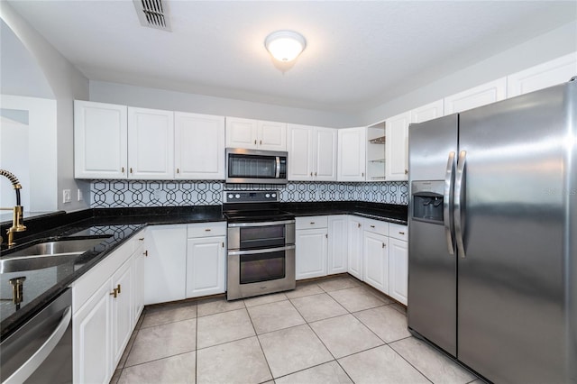 kitchen featuring white cabinets, backsplash, appliances with stainless steel finishes, and sink