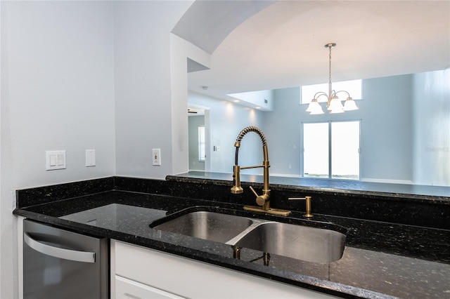 kitchen with pendant lighting, dark stone countertops, white cabinets, and sink