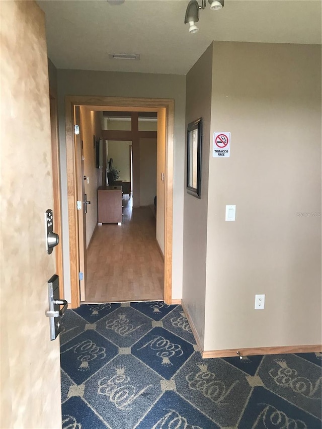 corridor with hardwood / wood-style flooring