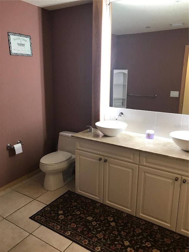 bathroom featuring tile patterned flooring, vanity, and toilet