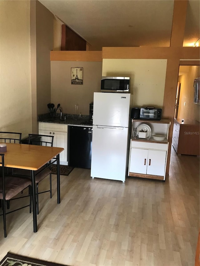 kitchen with black dishwasher, white fridge, white cabinetry, and light hardwood / wood-style flooring