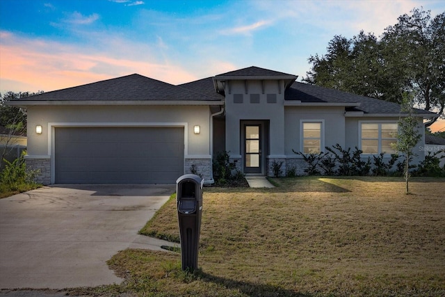 prairie-style home featuring a lawn and a garage