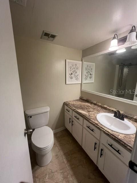 bathroom featuring vanity and toilet